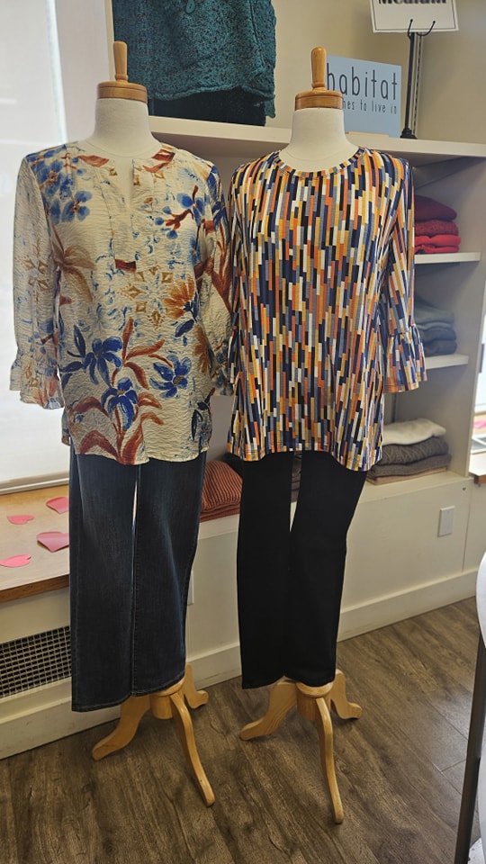 Floral blouse and geometric print top with dark pants on mannequins
